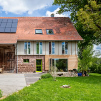 Ein umgebautes Bauernhaus mit großzügigen Fensterflächen und einem grünen Garten © Wolf-Dieter Gericke, Waiblingen