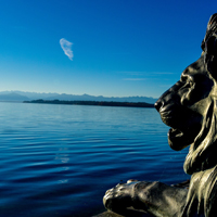 Blick auf Starnberger See über Löwenskulptur am Ufer